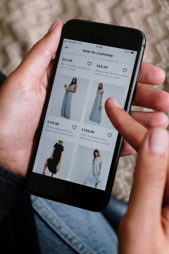 our-experience A person browsing clothing options on a smartphone for online shopping.