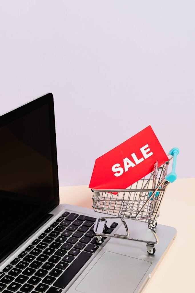 pexels photo 5632381 Mini shopping cart with sale tag on laptop for online shopping theme.